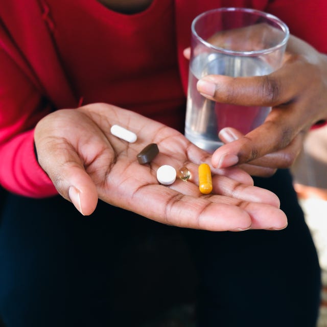 Người phụ nữ cầm những viên thuốc trong lòng bàn tay.